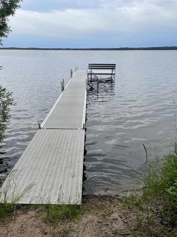 A wooden dock extending into calm water with a bench at the end. - Cozy Chalet Overlooking Yellow Lake, 10 Beds and Hot Tub <2 Hrs From The Cities (Danbury)