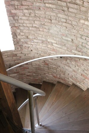 Un escalier en colimaçon avec un mur en briques en arrière-plan.