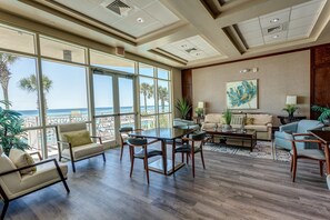 Relax in this inviting living area with a sofa, armchairs, and dining table, offering a view of the ocean.