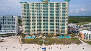 Un hôtel de grande hauteur doté de nombreux balcons, d’un espace piscine et offrant une vue sur la plage.
