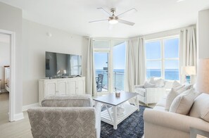 Relax in a spacious living room with a large flat-screen TV, comfortable seating area, and ocean views.