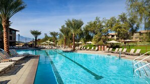 A swimming pool with lounge chairs and umbrellas, surrounded by palm trees and buildings. - Westin Desert Willow - 1 bedroom- Deluxe, Coachella 1st weekend - 820 sq ft (Palm Desert)