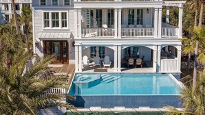 A large, two-story house with a swimming pool, multiple balconies, and a covered patio area. - Luxury Ocean Blvd.  POOL/HOT TUB, PUTTING GREEN, ROOF TOP (Isle of Palms)