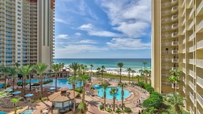 Un resort con varias piscinas, palmeras y vistas al océano.