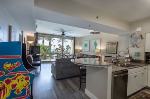 Una cocina moderna con una isla central, un comedor con vistas y un salón con un ventanal grande.