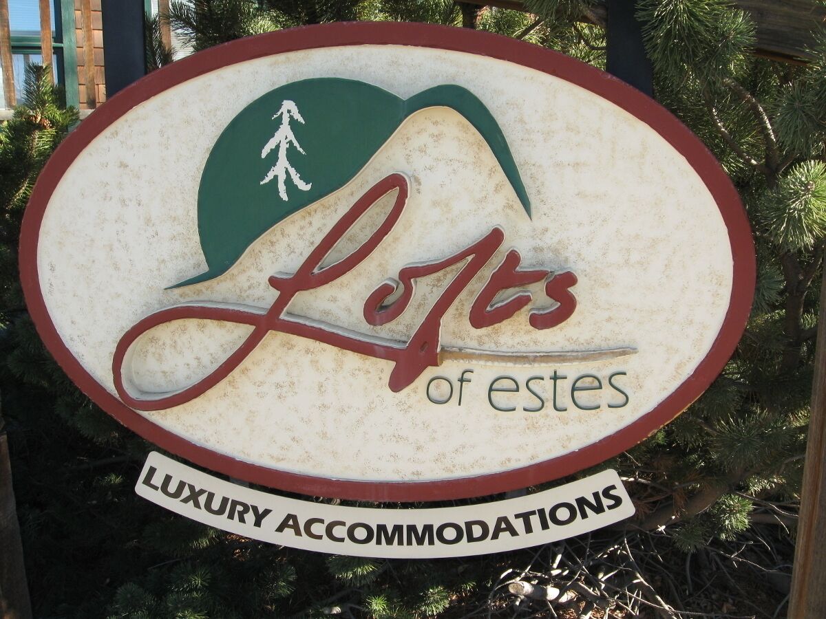 Placa indicando acomodações de luxo, 'Lofts of Estes'.