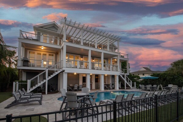 A two-story house with a pool, outdoor seating, and a staircase leading to the upper level. - Port of Call on Isle of Palms OCEAN FRONT, Pool, boardwalk, putting green (Isle of Palms)