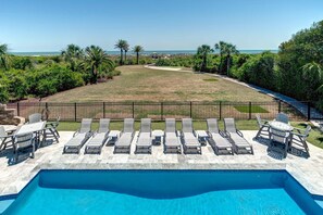 A pool area with lounge chairs and a view of the ocean. - Port of Call on Isle of Palms OCEAN FRONT, Pool, boardwalk, putting green (Isle of Palms)