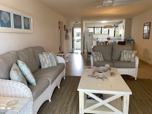 A living room with a sofa, armchairs, a coffee table, and a dining area in the background. - Banyan Court, a Family-Friendly Condo Close to Everything! (Barbados)