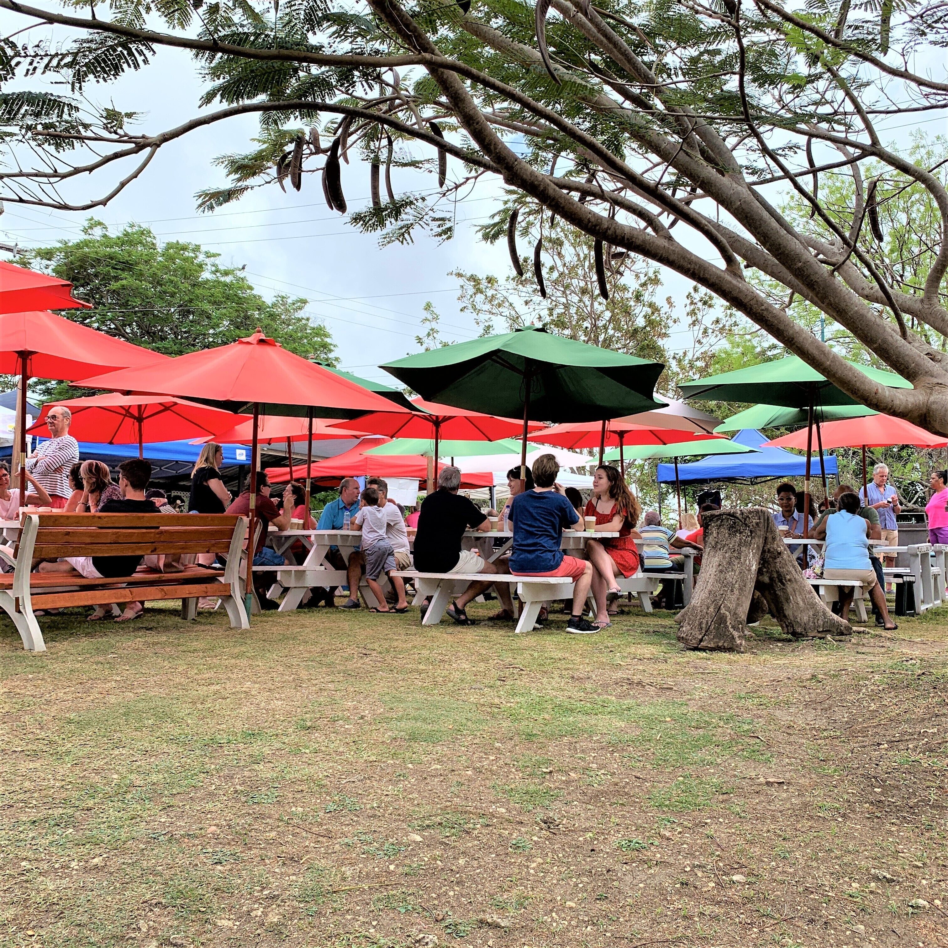 Un espace extérieur aménagé avec des tables de pique-nique et des parasols.