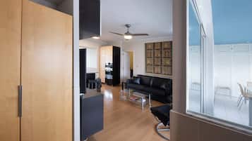 Un apartamento moderno con cocina, comedor y sala de estar con un sofá de cuero negro.