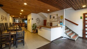 A restaurant interior with wooden ceiling, a counter, and a staircase. - Hotel Rio Piedras (Jericó)