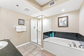 A modern bathroom with a glass-enclosed shower, a large bathtub, and a marble countertop. - 1st Floor Home Away From Home, Oceanfront Hot Tub | Crescent Shores - N 104 (North Myrtle Beach)