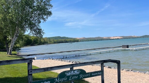 A wooden deck with a sign reading "Maple Lane Resort Guests Only." - Maple Lane Empire (Empire)