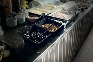 A buffet counter with various food items and containers. - Kadikoy Rihtim Hotel (Istanbul)