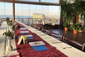 A long dining table with chairs, a red carpet, and potted plants. - Kadikoy Rihtim Hotel (Istanbul)