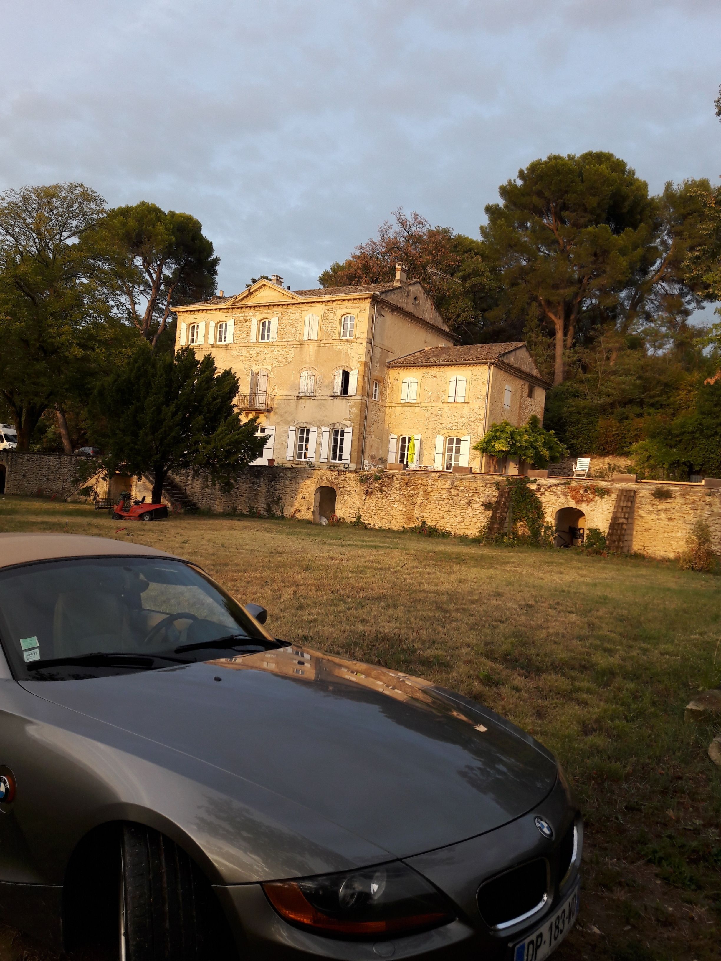 Ein großes Steinhaus mit vielen Fenstern und einem Auto davor.