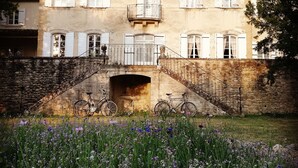A large, historic building with a stone facade, multiple windows with shutters, and a central entrance with a staircase leading up to a balcony. - Chambre d'hôtes Château MontPlaisir (Valreas)