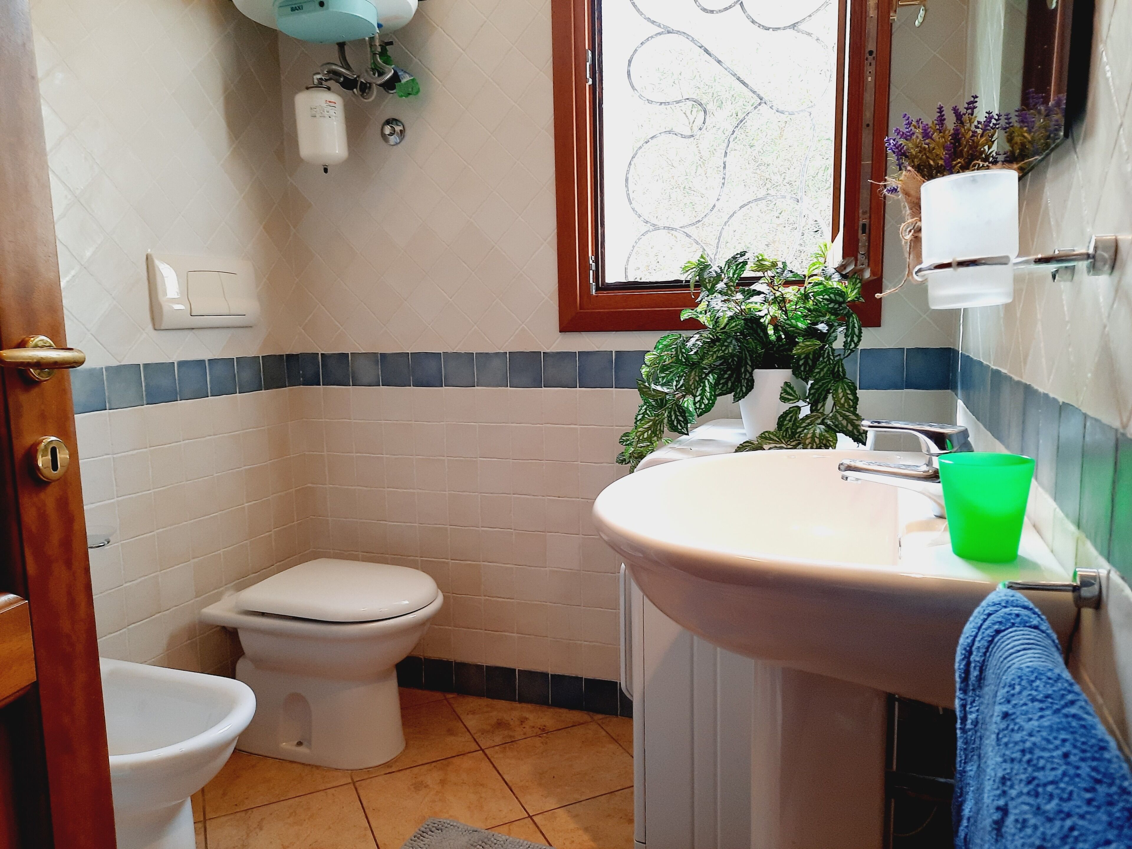 Un baño con inodoro, lavabo y ventana.