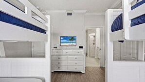 Een kamer met stapelbedden, een televisie aan de muur en een inloopkast.