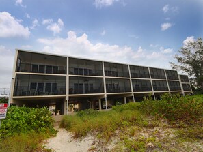 Un edificio de varios pisos con techo plano y ventanas grandes.