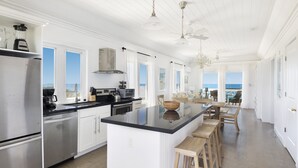 A spacious kitchen with a large island, stainless steel appliances, and a view to the outside. - Condo w/Views, Beach, Htd Pool, Golf Cart, Kayaks, Gym, Pickleball Court! (Governors Harbour)