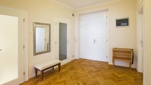 Ein Flur mit Holzboden, einer Bank und einem Holzschrank.