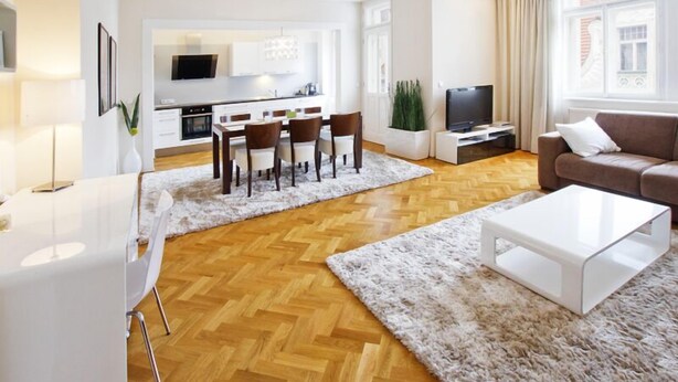 Ein modernes Wohnzimmer mit Essbereich, einem Flachbildfernseher und einer Couch.