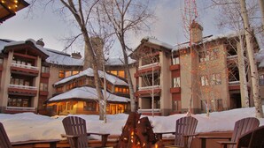 Un lodge con un focolare, posti a sedere all'aperto e un paesaggio innevato.