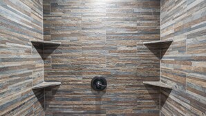 A bathroom with a stone-patterned wall, a central sink, and two corner shelves. - Elegant 2700 Sq Ft True Log Cabin-Private Hot Tub-Game Room-Pool Table-Best View Near Big Cedar (Ridgedale)