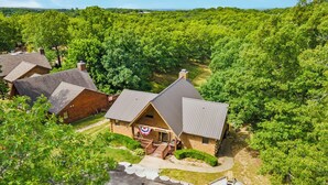 A lodge with a central building surrounded by dense forest.
