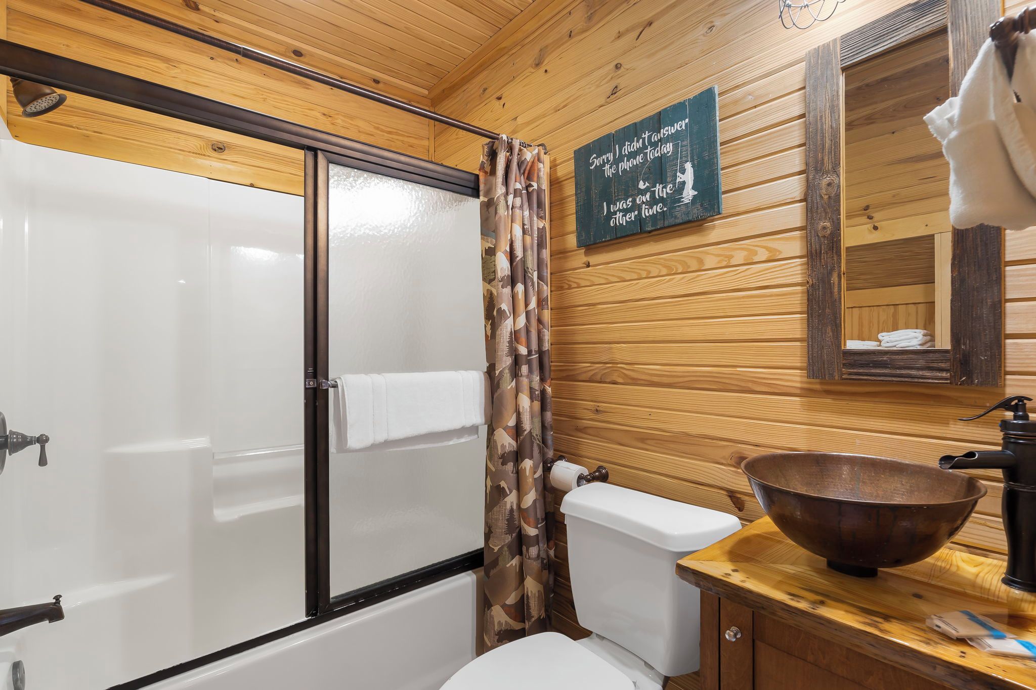 A bathroom with a shower, toilet, and sink.