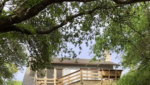 Une maison à deux étages avec une terrasse en bois et un garage.