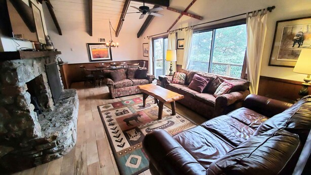Una sala de estar acogedora con chimenea, un sofá, una mesa de centro y un comedor.