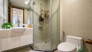 A modern bathroom with a glass-enclosed shower, a white sink, and a toilet. - AMAVI LUXURY - VINHOMES SPACIOUS AND COZY APT FOR FAMILY/GROUP - 4 BR  (Ho Chi Minh)