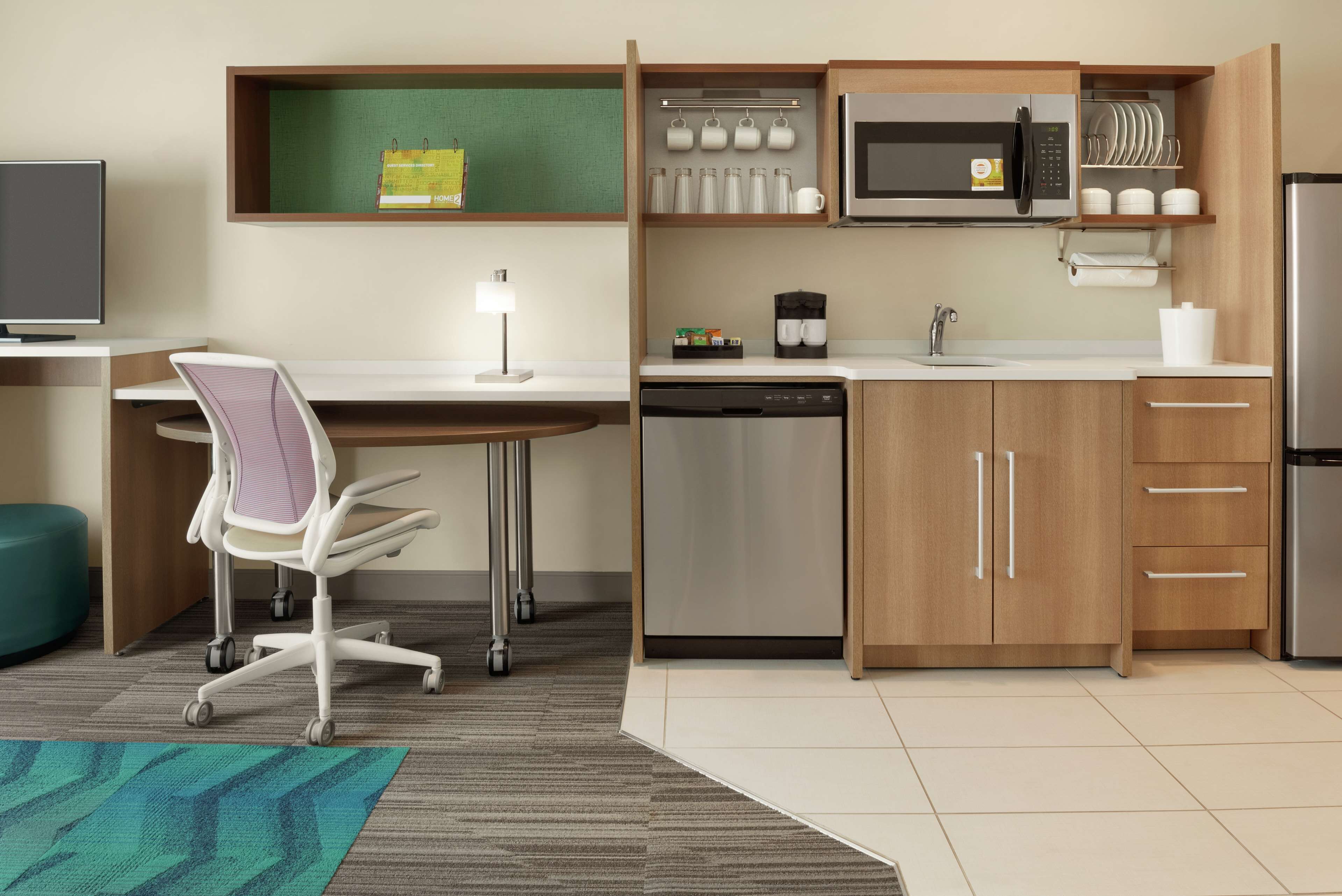 A compact kitchen with a microwave, coffee maker, and dishwasher.