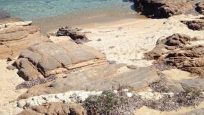 A rocky beach with clear turquoise water and a distant island. -  Villa With Swimming Pool In Front Of Almost Private Beach  (PAROS)