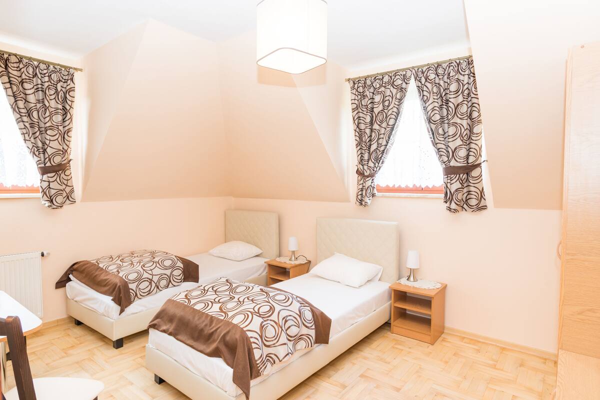 Ein Schlafzimmer mit zwei Betten, einem kleinen Tisch und einem Stuhl.