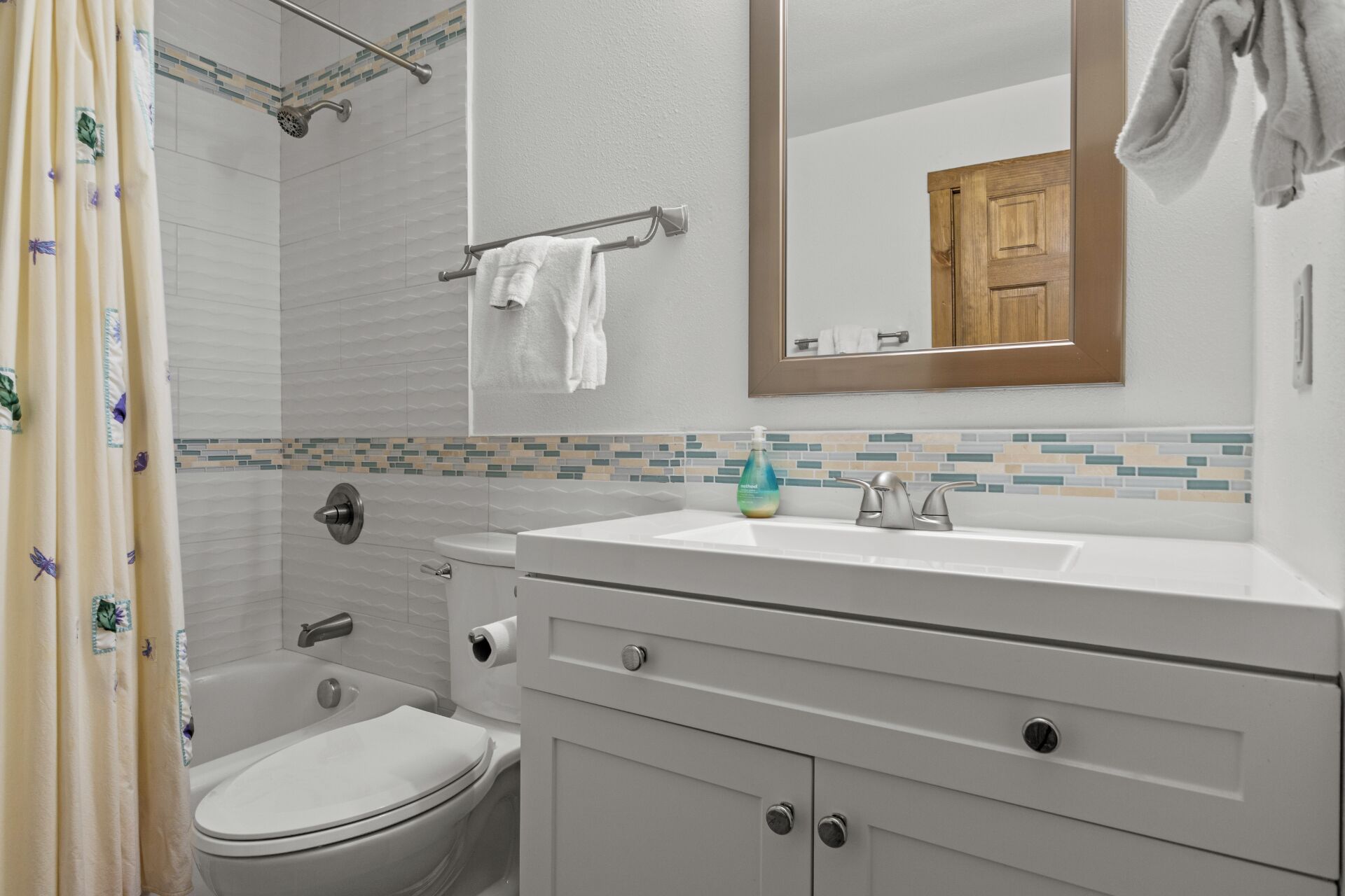 Une salle de bain comprenant des toilettes, un lavabo et un espace douche.