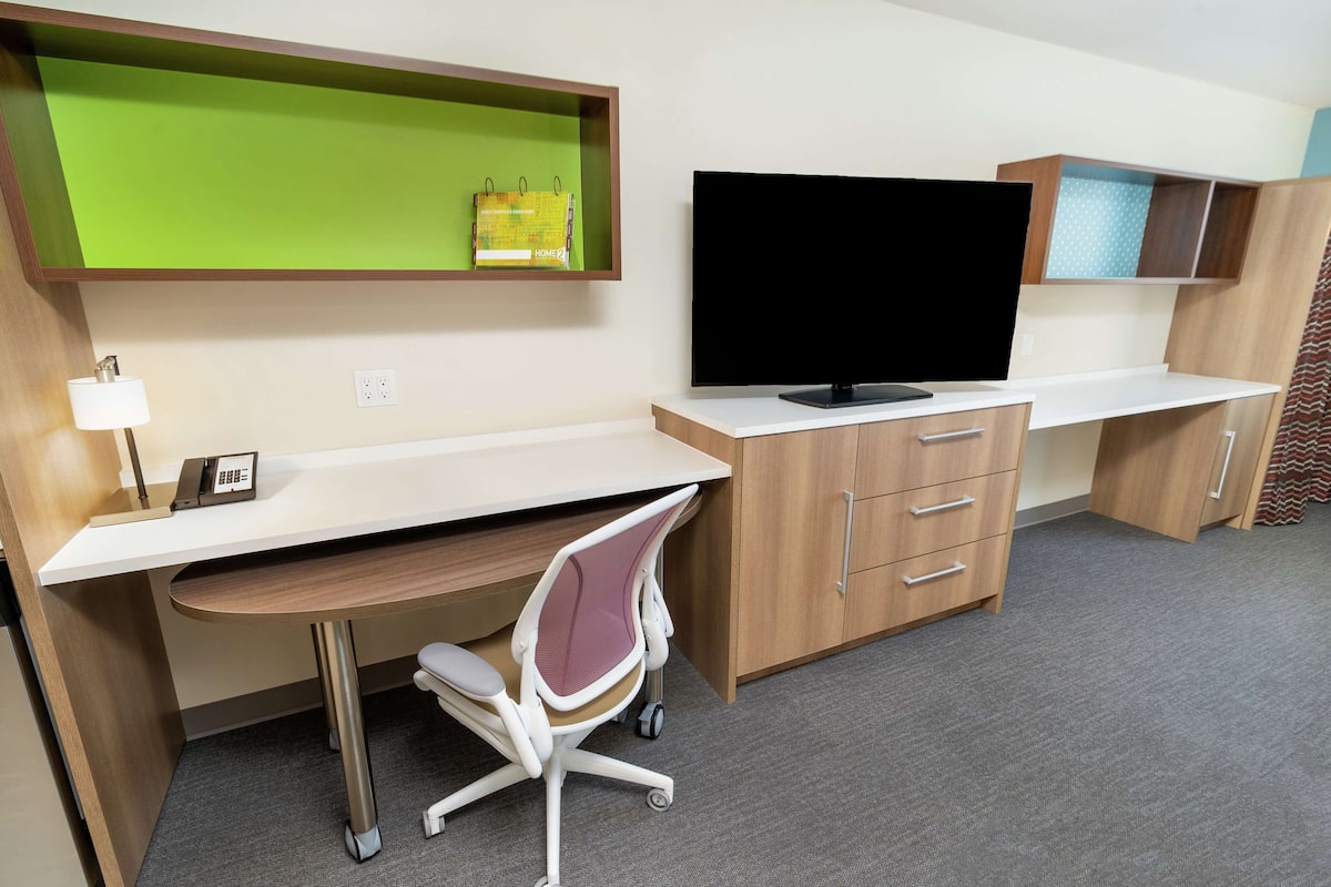 Escritorio, cortinas blackout y tabla de planchar con plancha
