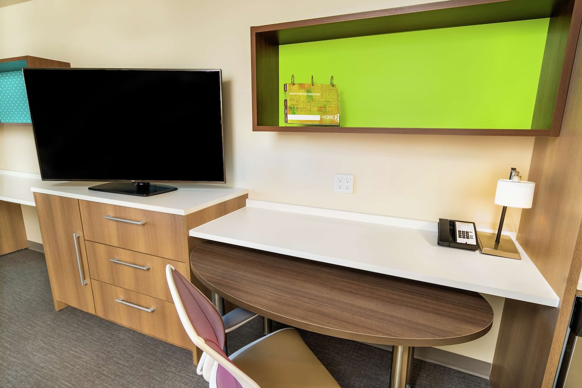 Escritorio, cortinas blackout y tabla de planchar con plancha