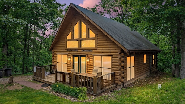 A log cabin with a porch, large windows, and a deck. - Secluded Lodge w HotTub_Loft w Games_Near Big Cedar Trophy Buck_Pet Friendly_Car Charger_Slide (Ridgedale)