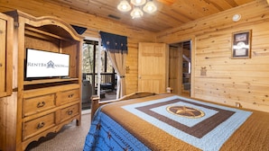 A wooden cabin bedroom with a bed, dresser, and a television displaying RENTBRJONSON.COM. - Upscale Log Cabin Over 2400 Sq Ft- Game Table-Free Tickets-Hot Tub-Car Charger-Near Thunder Ridge (Ridgedale)