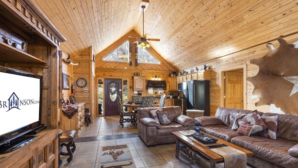 A spacious log cabin interior with a living room, kitchen, and dining area. - Upscale Log Cabin Over 2400 Sq Ft- Game Table-Free Tickets-Hot Tub-Car Charger-Near Thunder Ridge (Ridgedale)