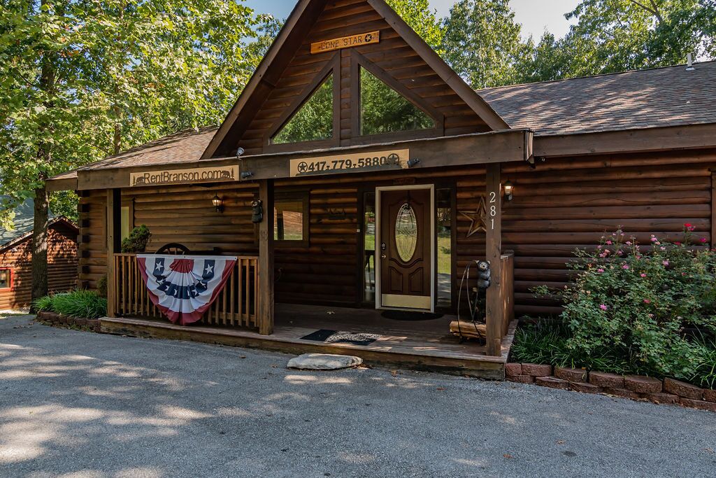Ein rustikales Holzhaus mit Veranda, einer Flagge und der Telefonnummer von RentBrazon.com.
