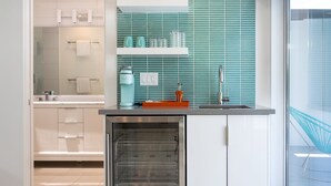 A modern kitchen with a built-in oven, a countertop with a coffee machine, and a window with a view of the outside. - Alexander Sunrise - Luxury Midcentury Retreat (Palm Springs)