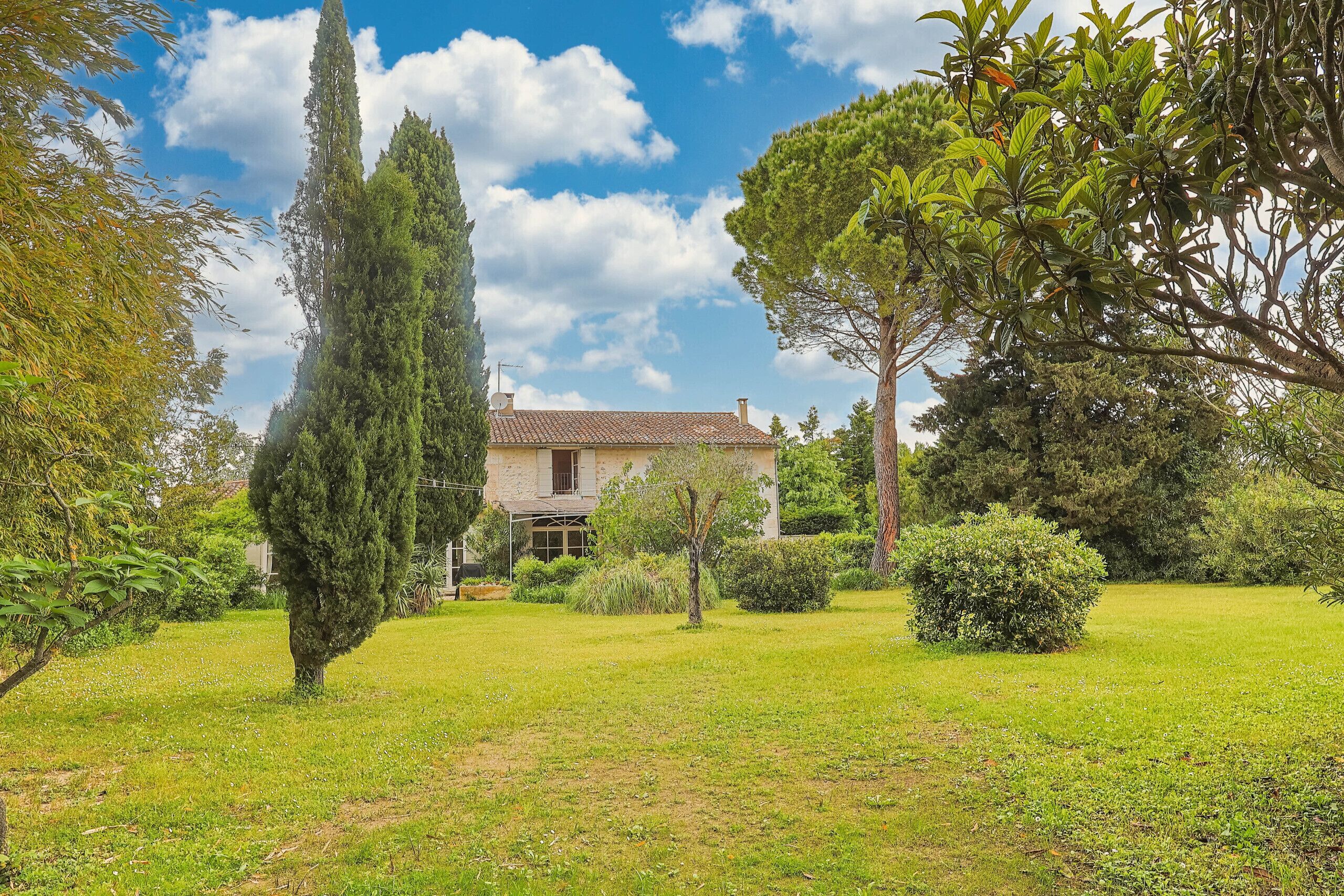 A house surrounded by a well-maintained garden with various trees and shrubs.