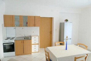 Compact kitchen with stove, sink, and refrigerator, perfect for small-scale living or dining.