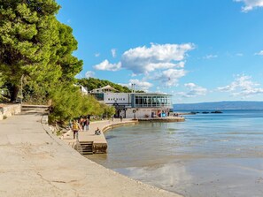 A waterfront building with a glass facade, a flag, and a sign reading "BAČVICE". - Apartments Slavica, (14202), Split, hr (Split)