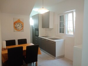 Enjoy meals in the kitchen and dining area, featuring an oven, stainless steel sink, and wooden table.